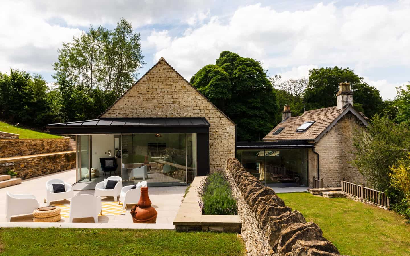 Cambray House stone cottages with contemporary glass extensions, outdoor terrace, and garden