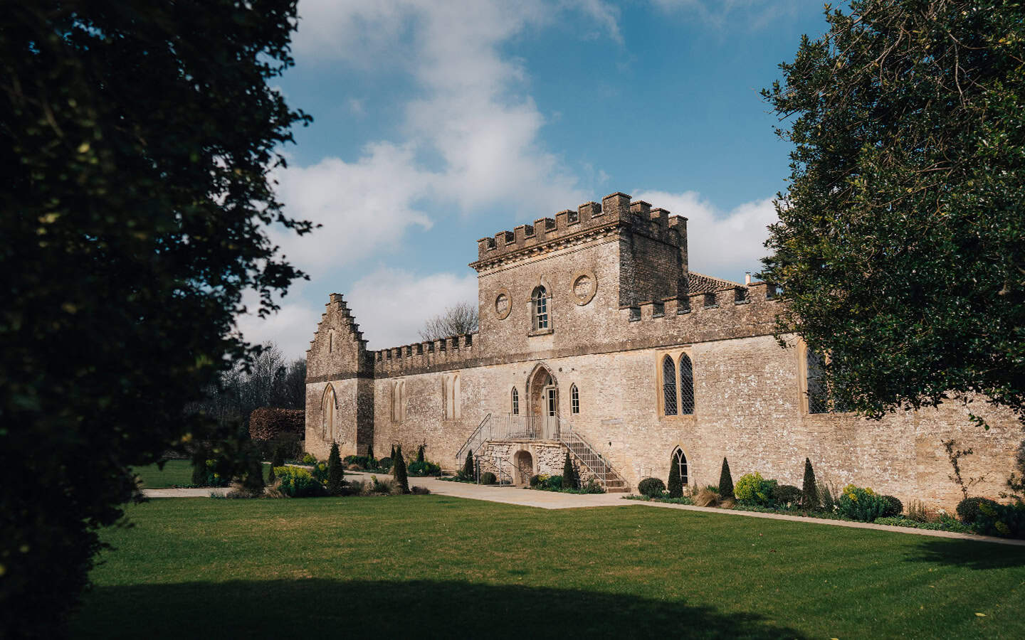 Ivy Lodge historic stone castle-like building with castellated tower set in parkland lawns