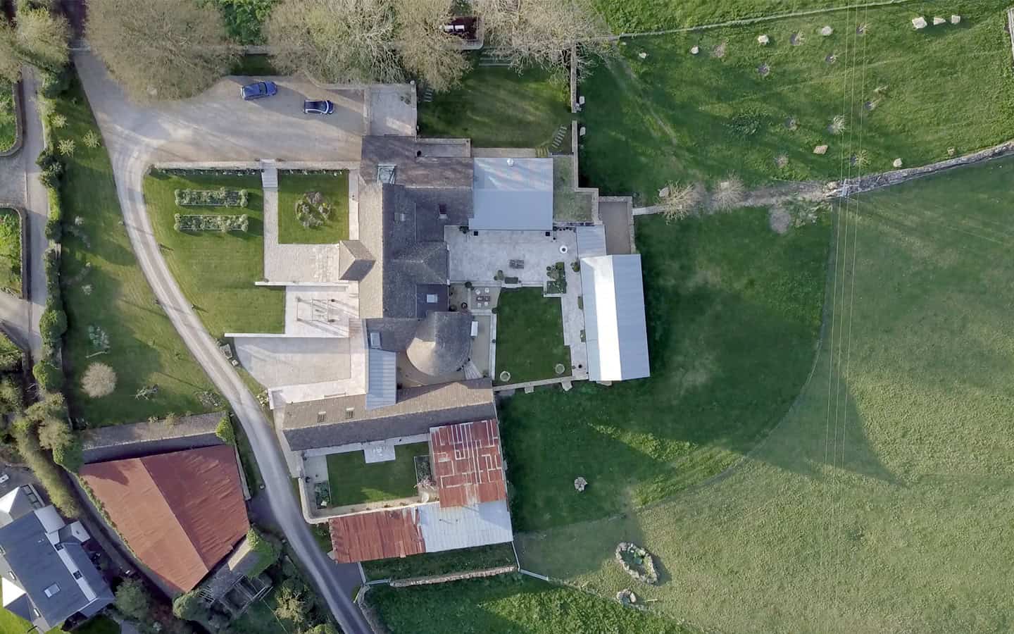 Vale Farm aerial view of converted Cotswold barn complex with courtyard and surrounding fields
